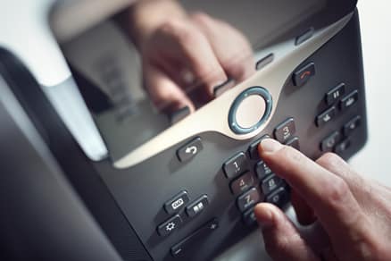 Example of a hand dialling a number on an internet phone